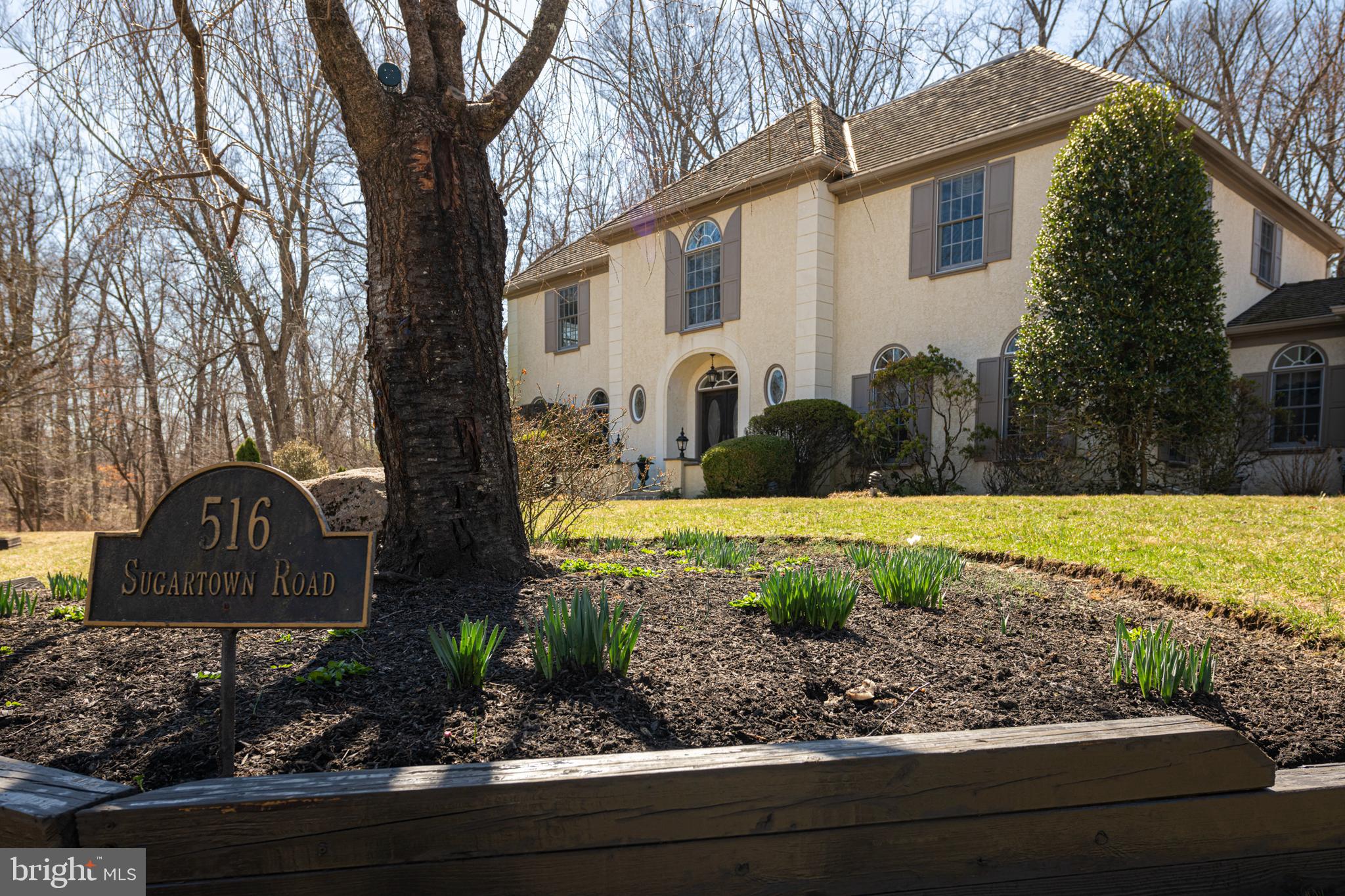 516 Sugartown Road Devon, PA 19333 - Photo 2 of 77 a front view of a house with a yard and large tree