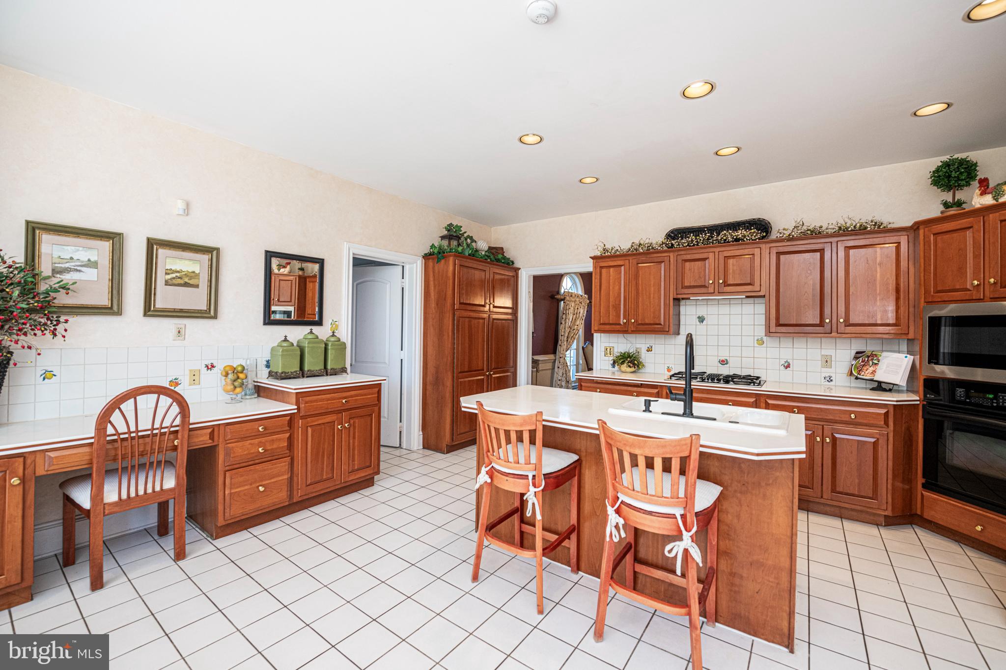 516 Sugartown Road Devon, PA 19333 - Photo 28 of 77 a kitchen with stainless steel appliances granite countertop a stove a sink dishwasher and a refrigerator with wooden cabinets