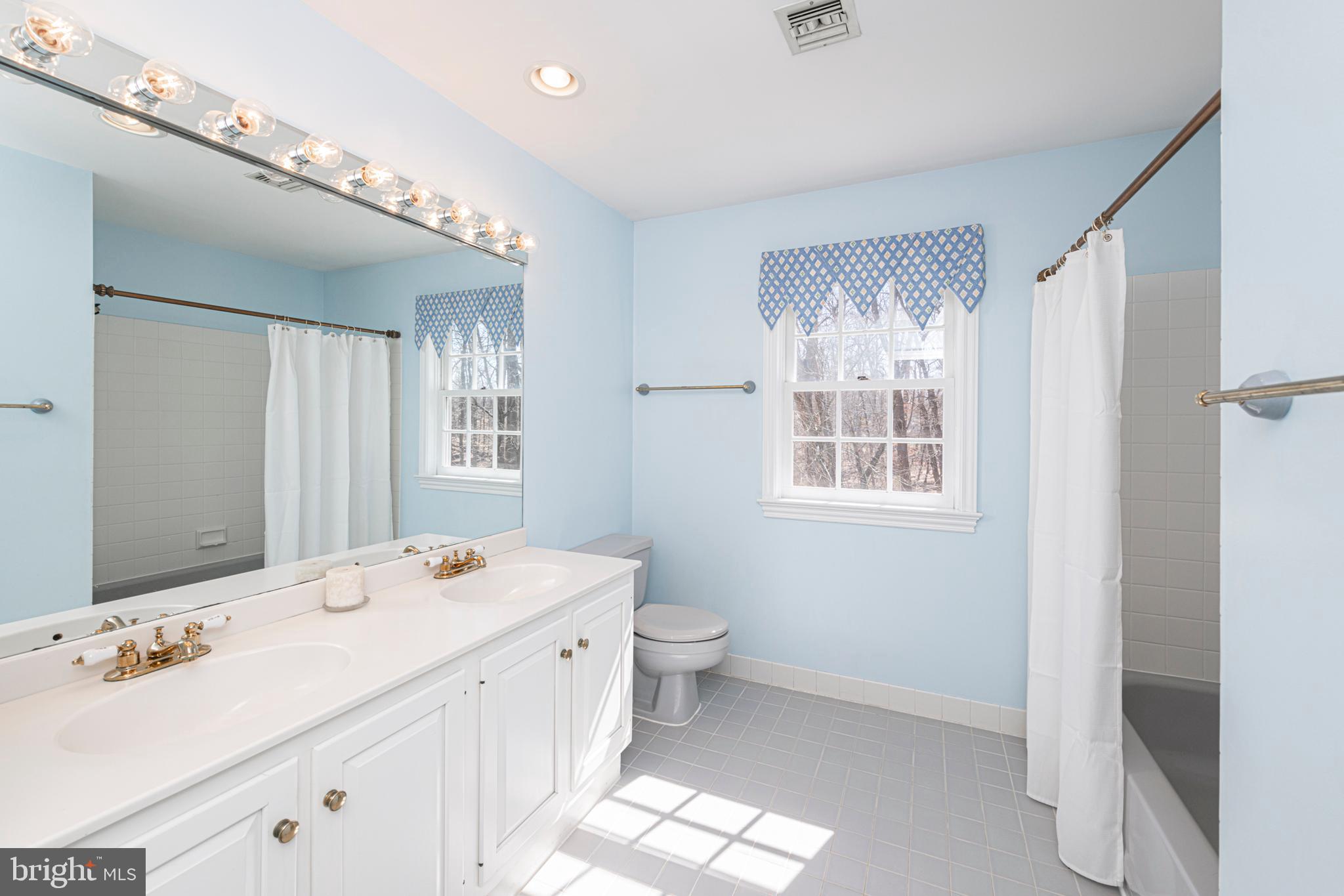 516 Sugartown Road Devon, PA 19333 - Photo 51 of 77 a spacious bathroom with a double vanity sink toilet and a mirror