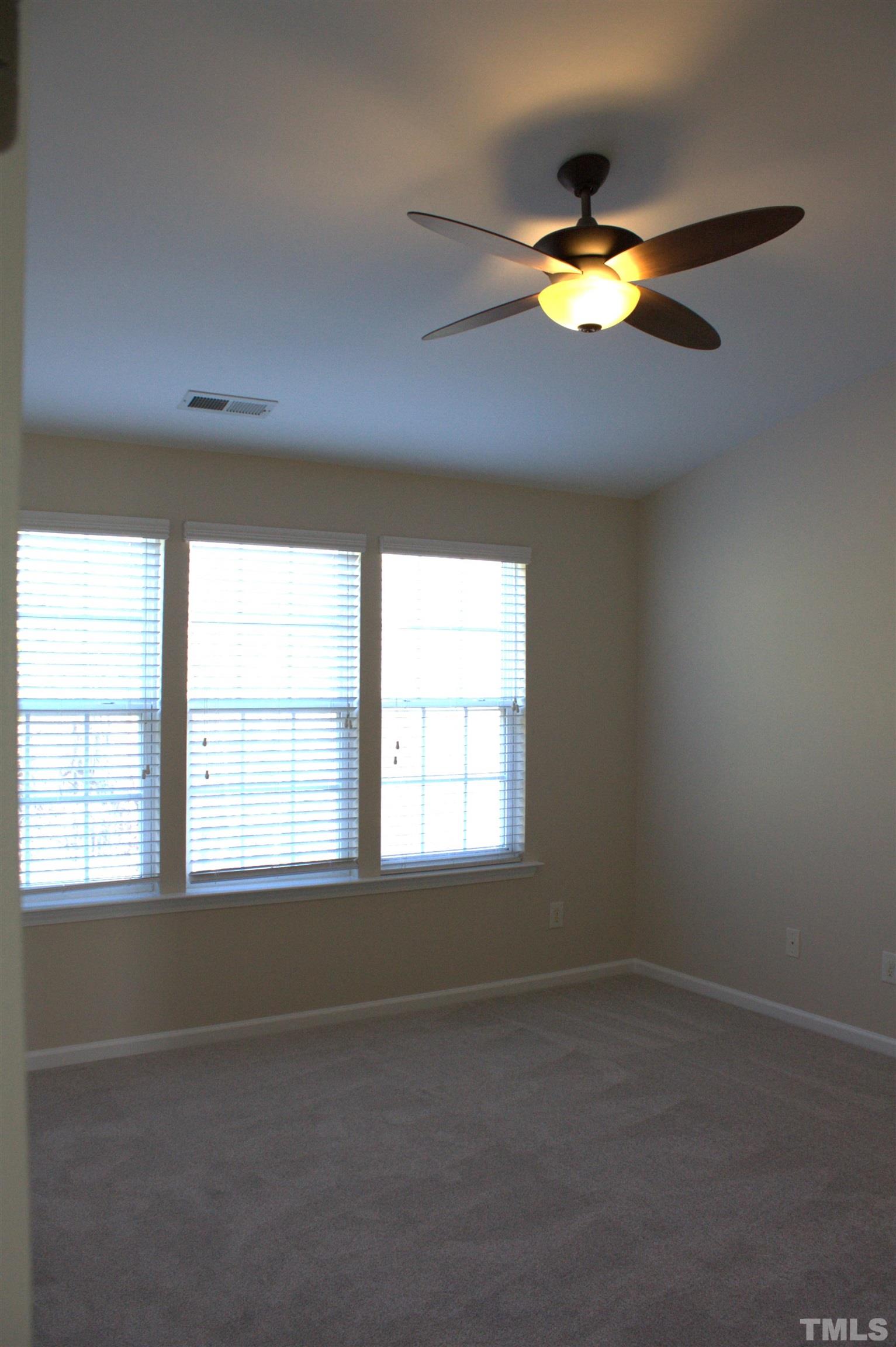 7802 Spungold Street Raleigh, NC 27617 - Photo 11 of 23 an empty room with a window and a fan