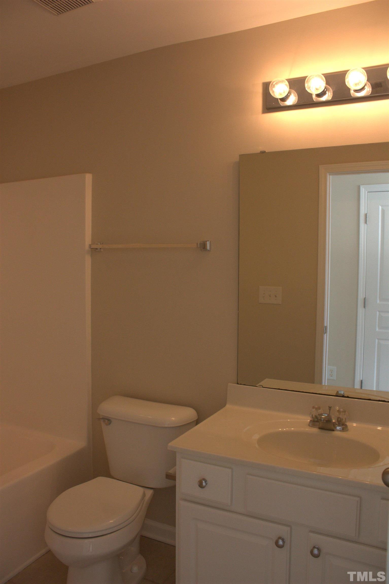 7802 Spungold Street Raleigh, NC 27617 - Photo 14 of 23 a bathroom with a toilet a sink and mirror