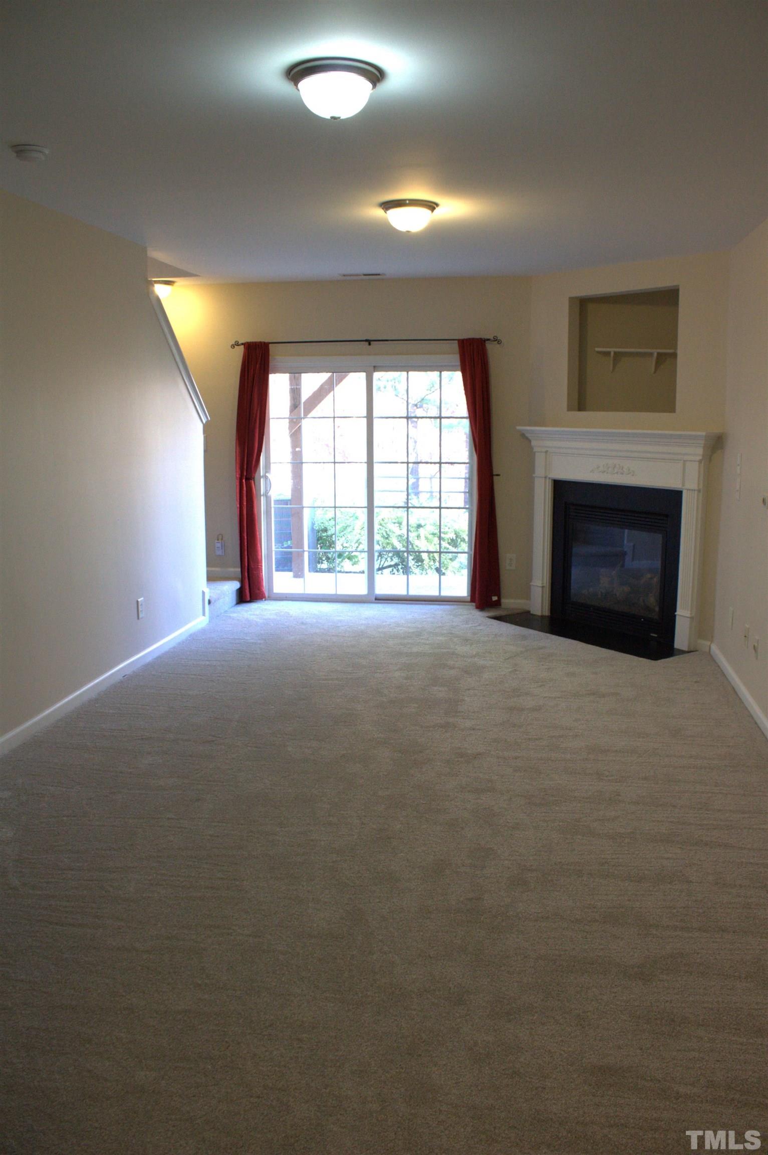 7802 Spungold Street Raleigh, NC 27617 - Photo 15 of 23 a view of an empty room with a fireplace and a window
