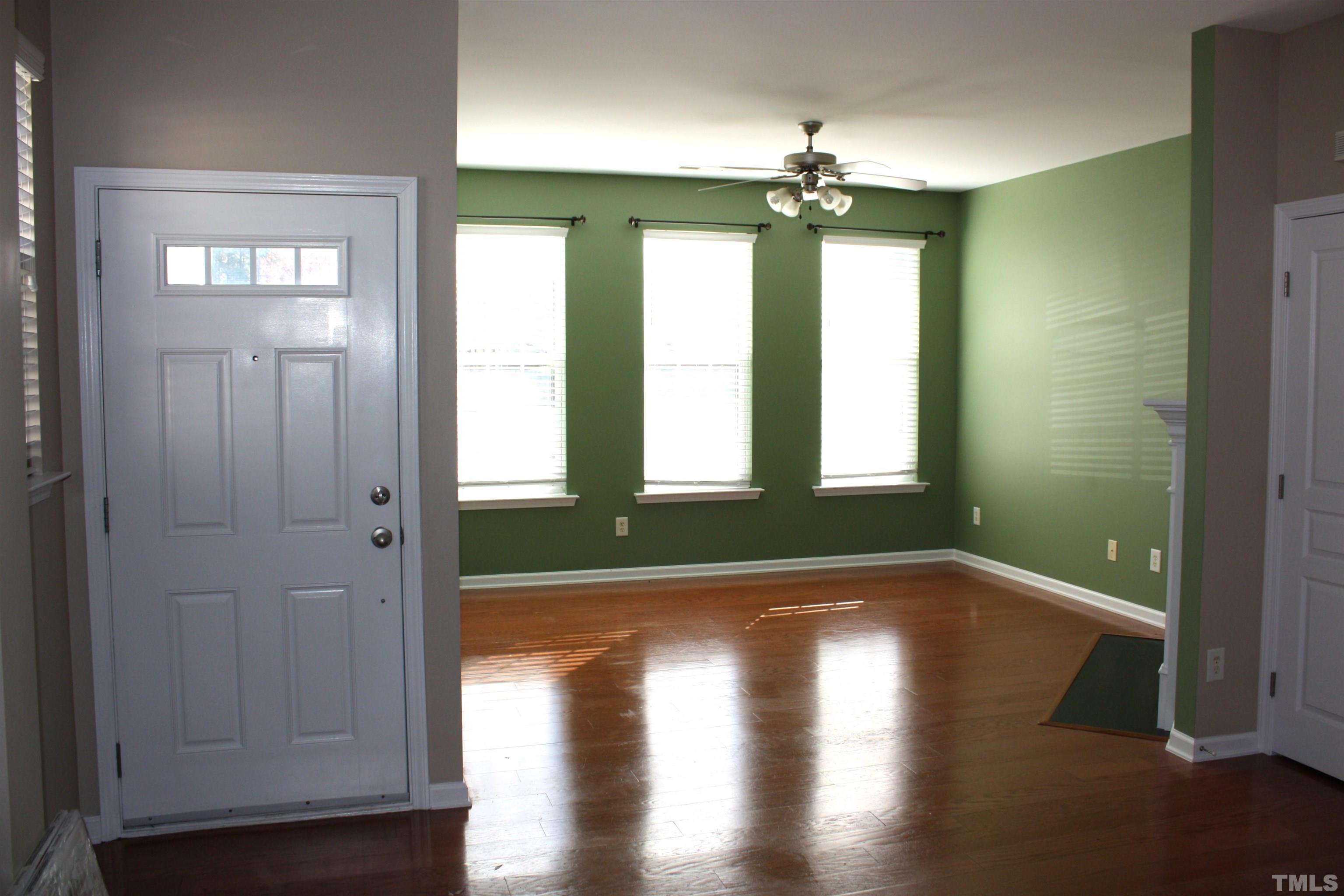 7802 Spungold Street Raleigh, NC 27617 - Photo 4 of 23 a view of livingroom with window and wooden floor