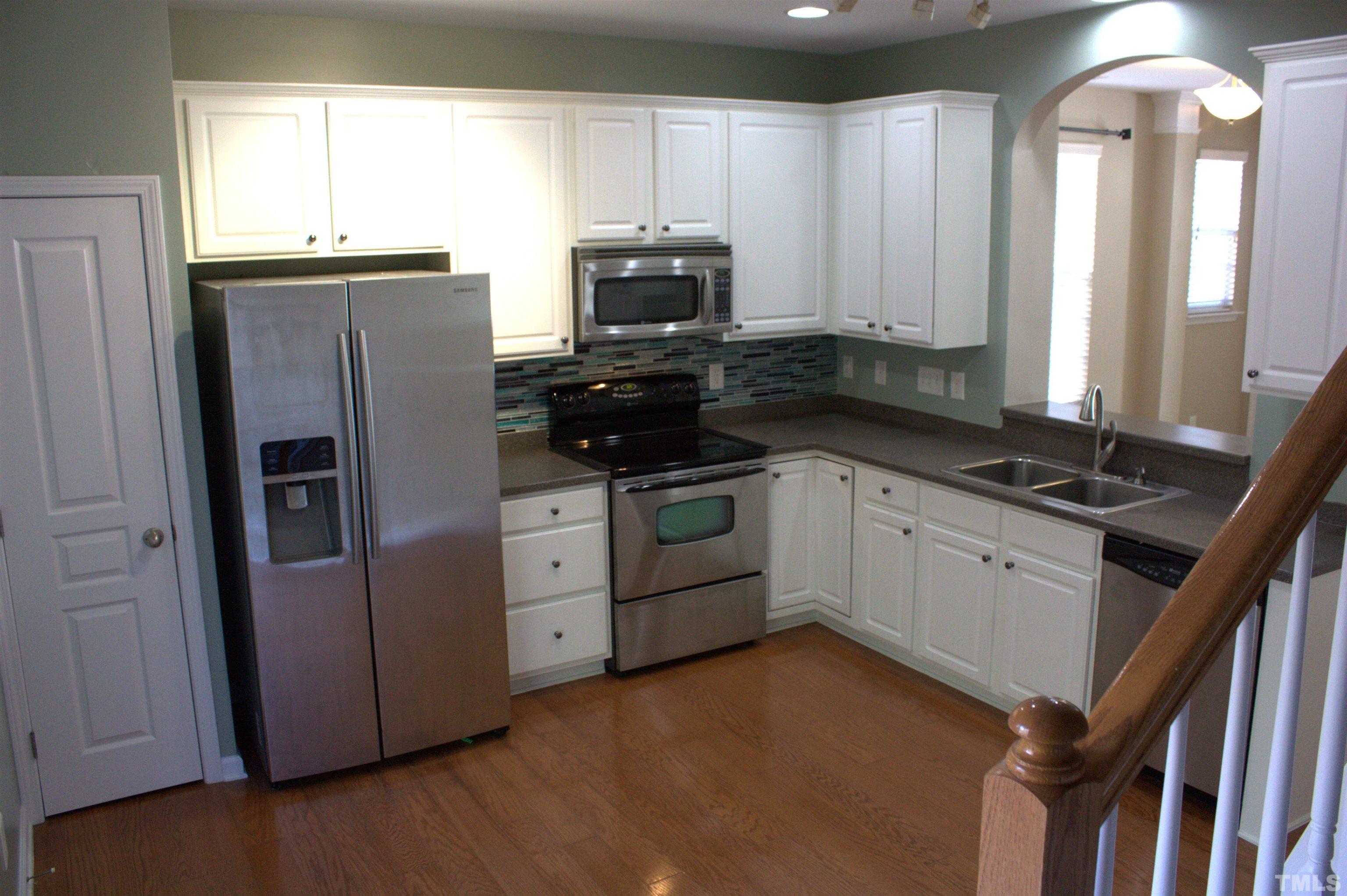 7802 Spungold Street Raleigh, NC 27617 - Photo 7 of 23 a kitchen with stainless steel appliances a refrigerator sink and microwave