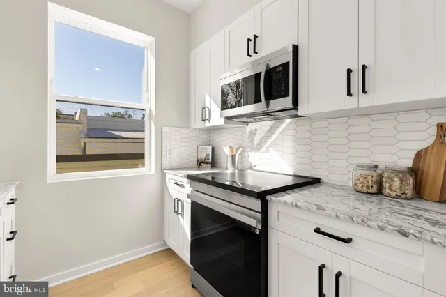 a kitchen with stainless steel appliances granite countertop a sink and a stove