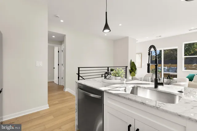 a kitchen with granite countertop a sink and a wooden floor