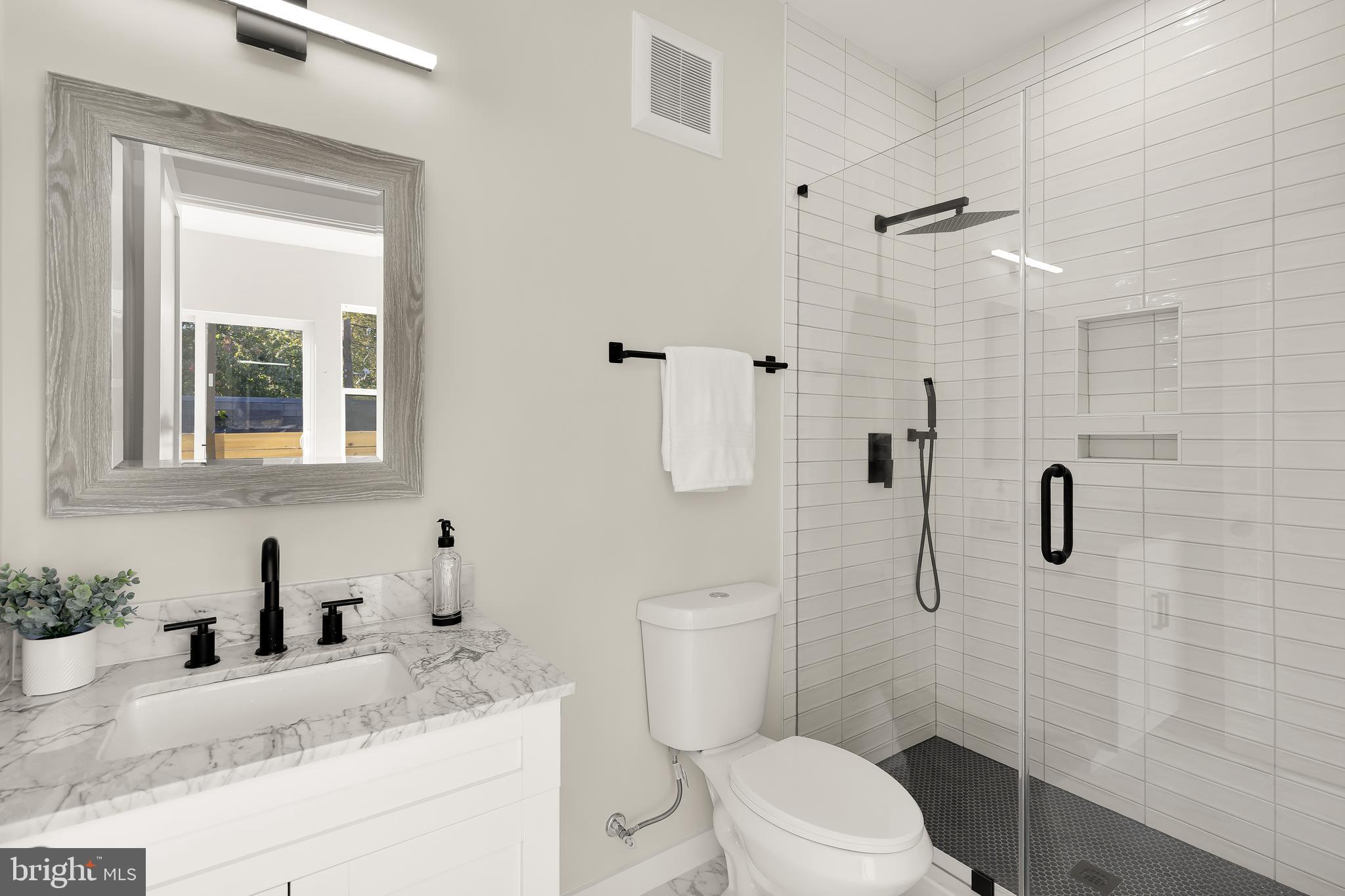 2606 41st Street Northwest, Unit PH Washington, DC 20007 - Photo 18 of 29 a bathroom with a granite countertop sink toilet a mirror and shower