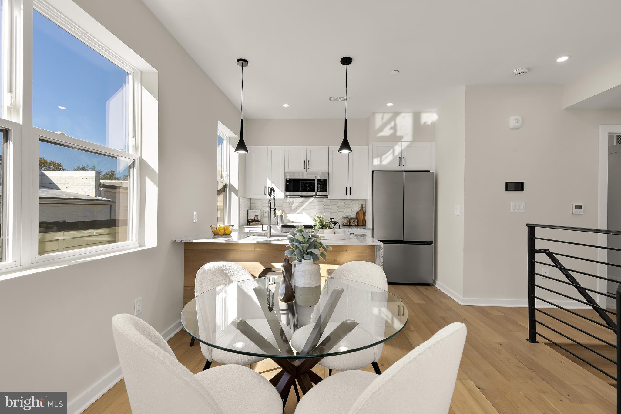 2606 41st Street Northwest, Unit PH Washington, DC 20007 - Photo 5 of 29 a view of a dining room with furniture a kitchen and chandelier
