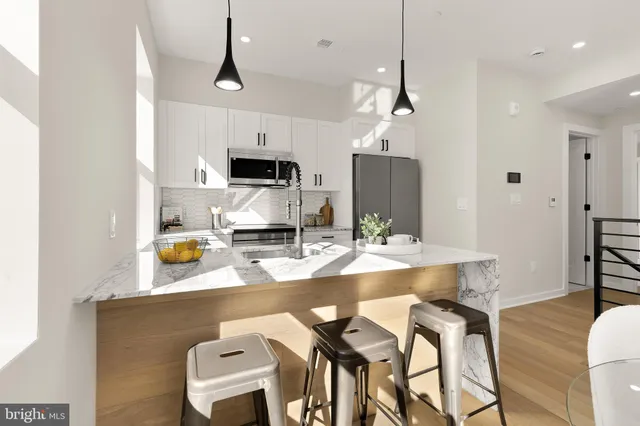 a kitchen with kitchen island granite countertop a sink and a stove