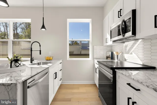 a kitchen with a sink and a stove top oven with wooden floor