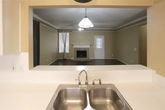 an empty room with wooden floor fireplace and windows