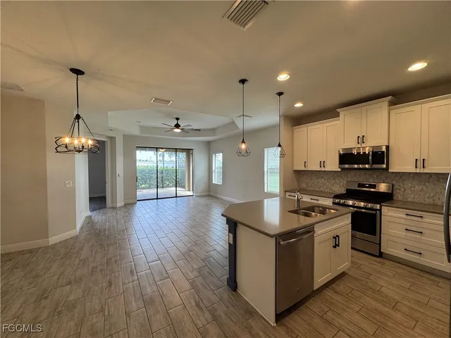 a kitchen with stainless steel appliances granite countertop a stove and a wooden floors