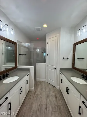 a spacious bathroom with a granite countertop sink mirror and shower