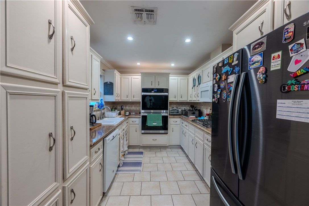 1201 Devon Drive Corpus Christi, TX 78404 - Photo 6 of 23 a kitchen with stainless steel appliances granite countertop a refrigerator and a sink