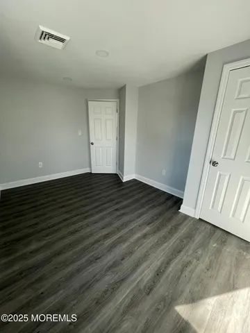 a view of an empty room and wooden floor