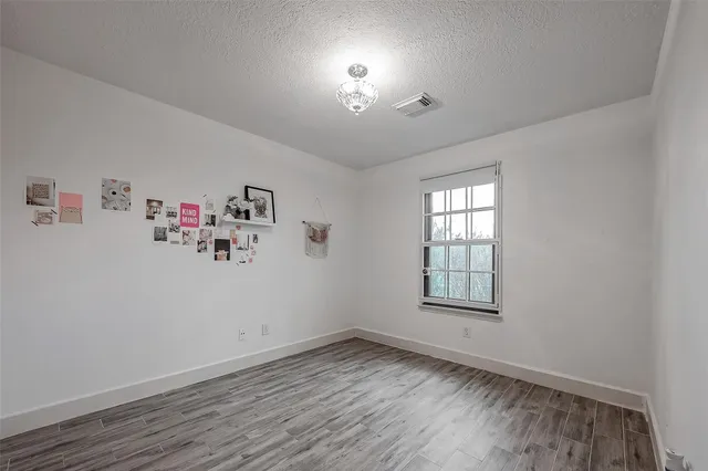an empty room with ceiling fan and window