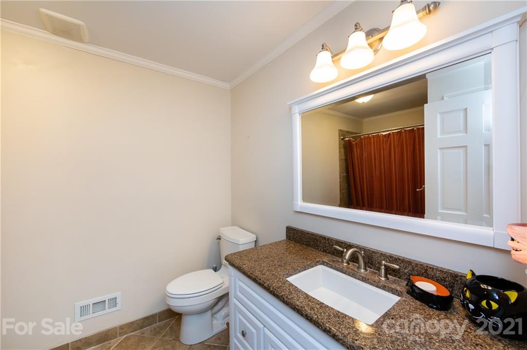 515 Windy Hill Road York, SC 29745 - Photo 34 of 45 a bathroom with a granite countertop sink a toilet and a mirror
