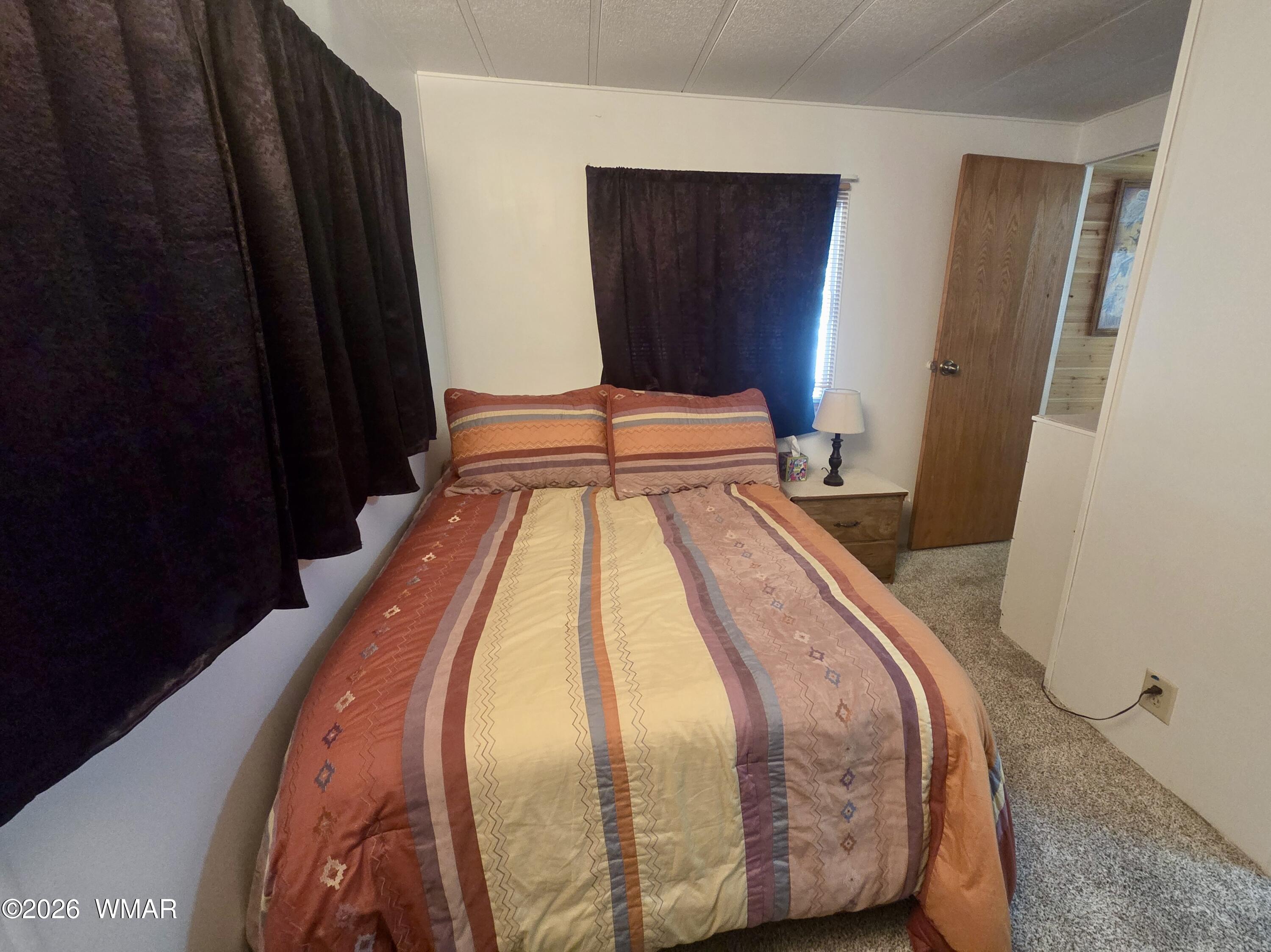 727 South Butler Street Eagar, AZ 85925 - Photo 18 of 32 a bed sitting in a bedroom next to a wooden door
