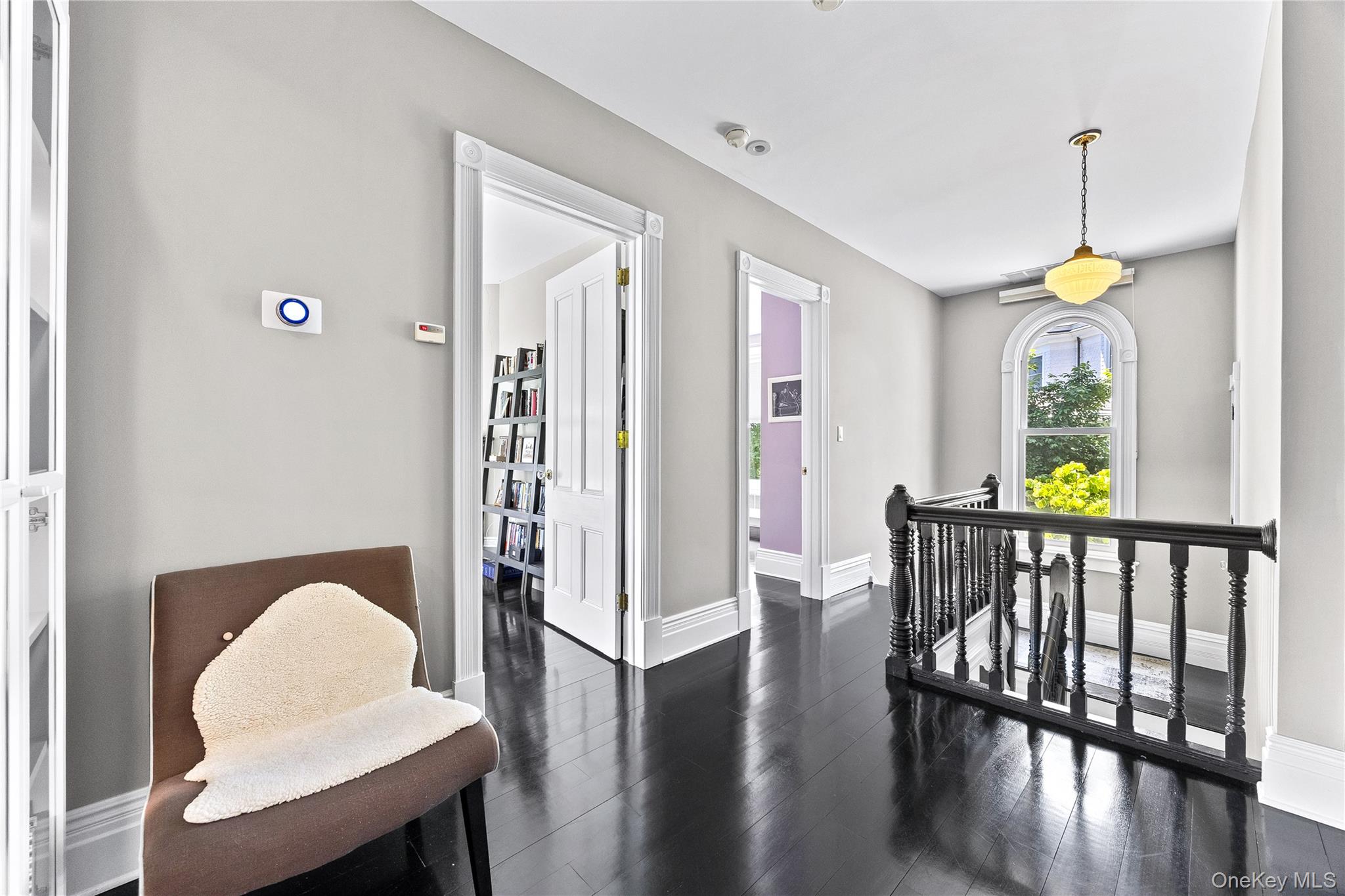 19 Howe Place Bronxville, NY 10708 - Photo 16 of 37 Upper landing featuring dark wood-finish flooring, white trim, and a black balustrade