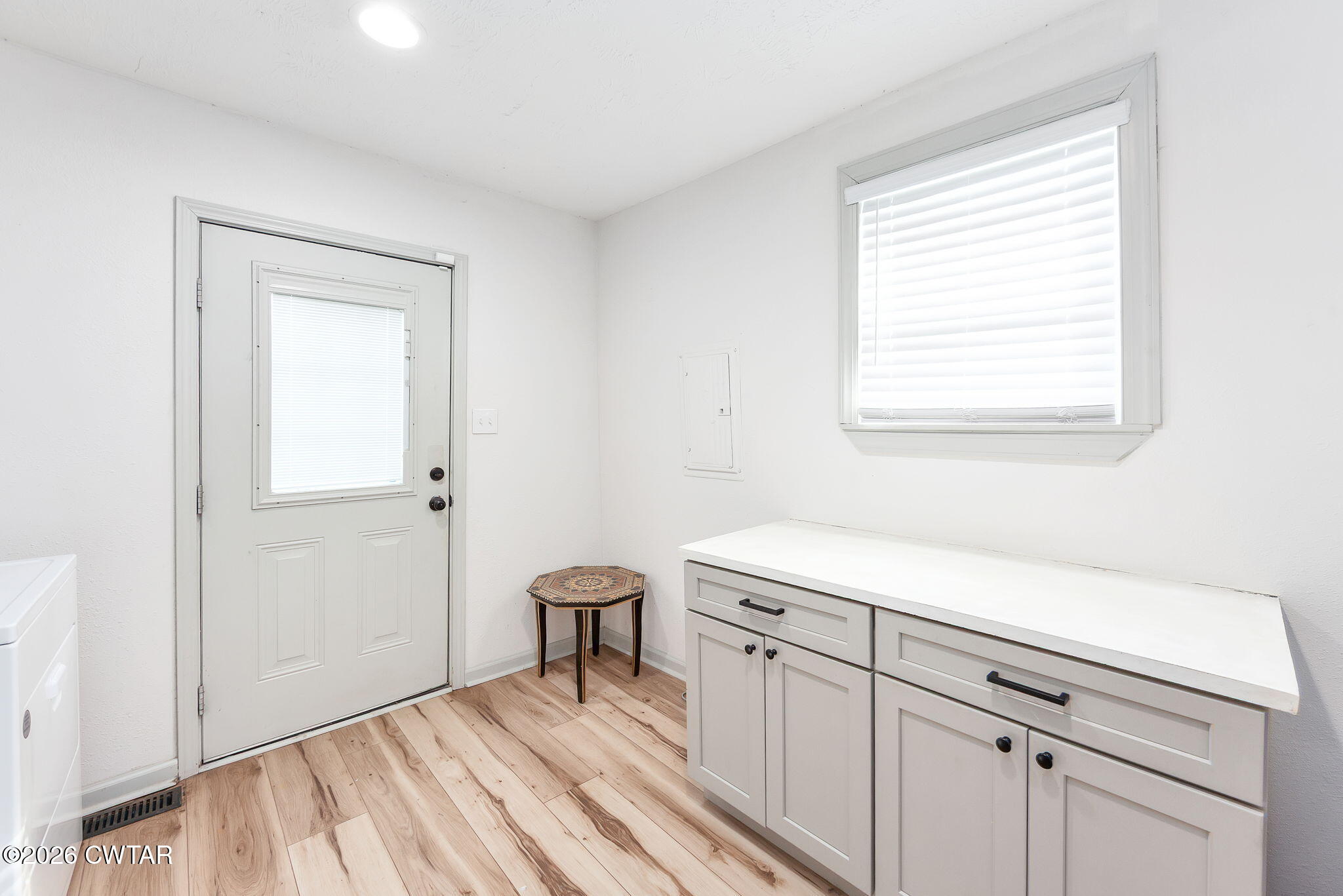 209 Hatton Street Jackson, TN 38301 - Photo 16 of 20 a utility room with a window dryer and white cabinets