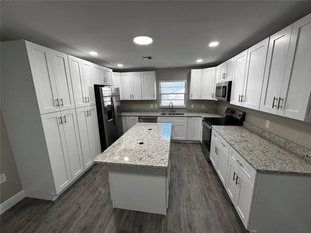 a large kitchen with stainless steel appliances sink a microwave and cabinets