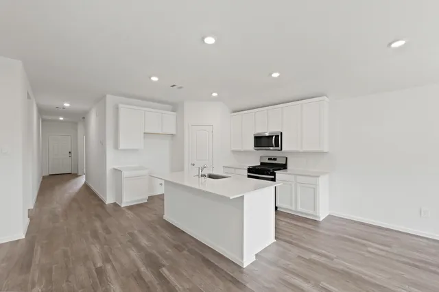 a kitchen with stainless steel appliances kitchen island sink refrigerator and stove