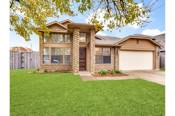 a front view of a house with a garden and yard