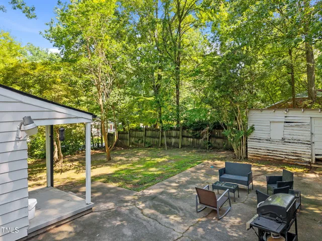 a view of a chair and tables in the backyard of the house