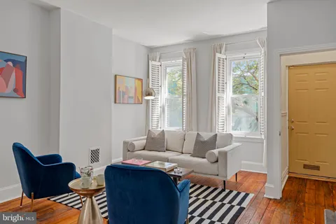 a living room with furniture and two window