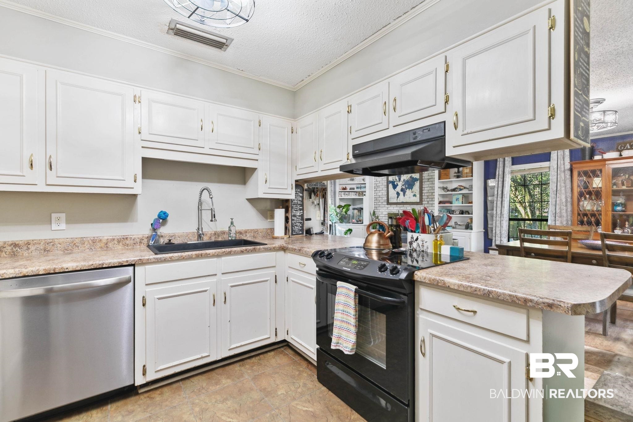107 Rainer Circle Daphne, AL 36526 - Photo 14 of 31 Kitchen with black / electric stove, stainless steel dishwasher, a textured ceiling, white cabinetry, and a peninsula