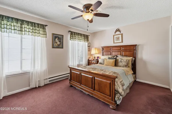 a bed sitting in a spacious bedroom next to a window