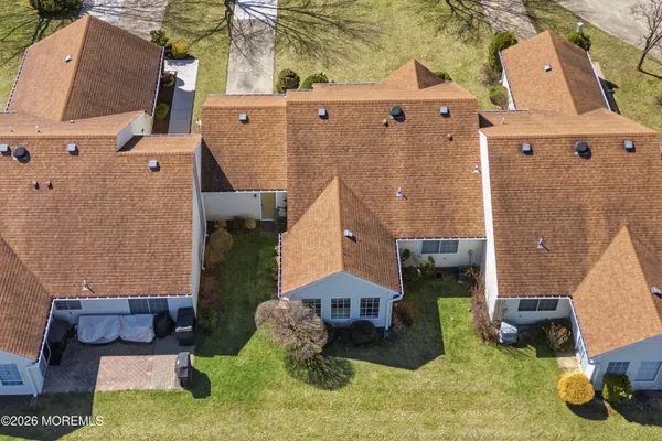an aerial view of a house with yard and seating space