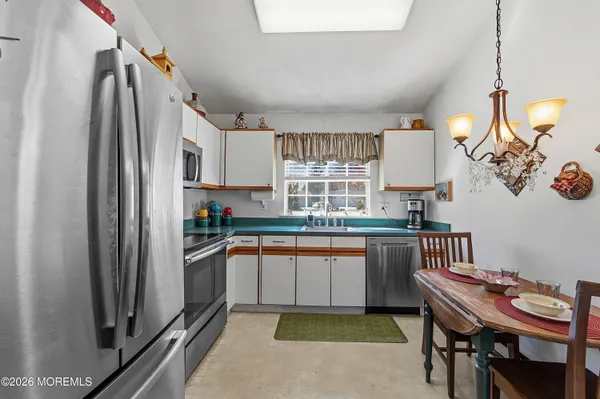 a kitchen with stainless steel appliances granite countertop a sink and a refrigerator