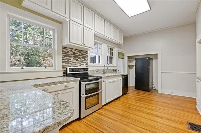 a kitchen with stainless steel appliances granite countertop a stove a sink and a refrigerator