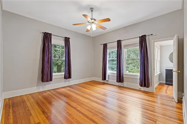 a view of a livingroom with a chandelier fan and windows
