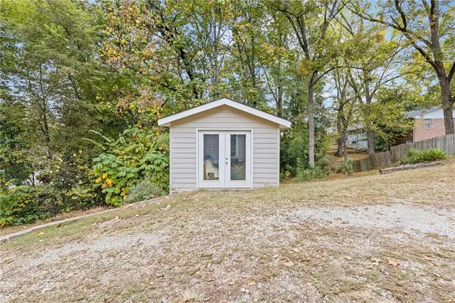 a front view of a house with a garden and trees