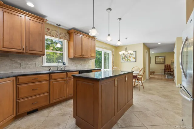 a kitchen with stainless steel appliances granite countertop a stove a sink and a refrigerator