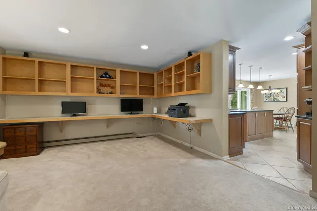 a view of an empty room with cabinet and mirrors