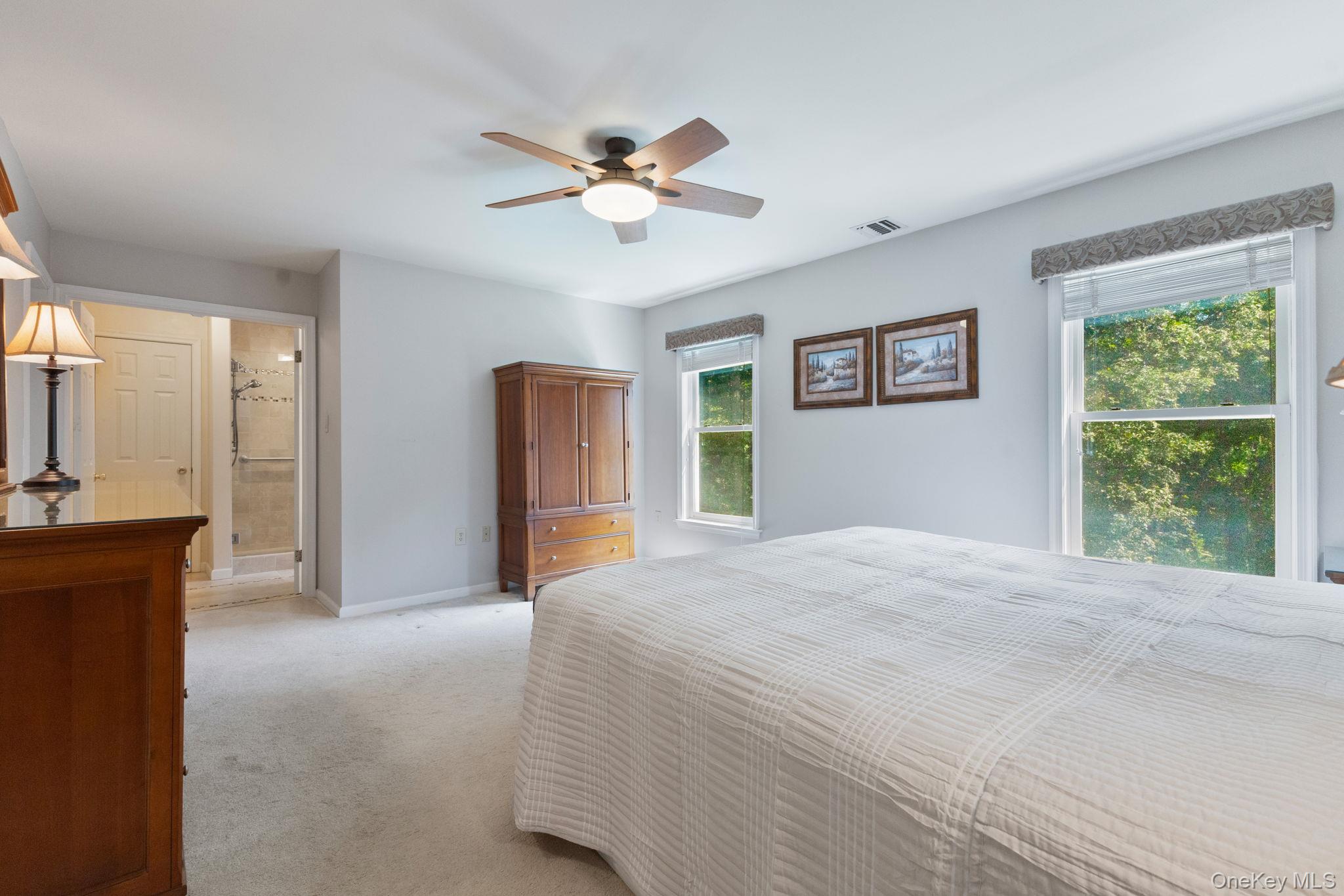 9 Windswept Circle Brewster, NY 10509 - Photo 31 of 43 a bedroom with a large bed and a chandelier