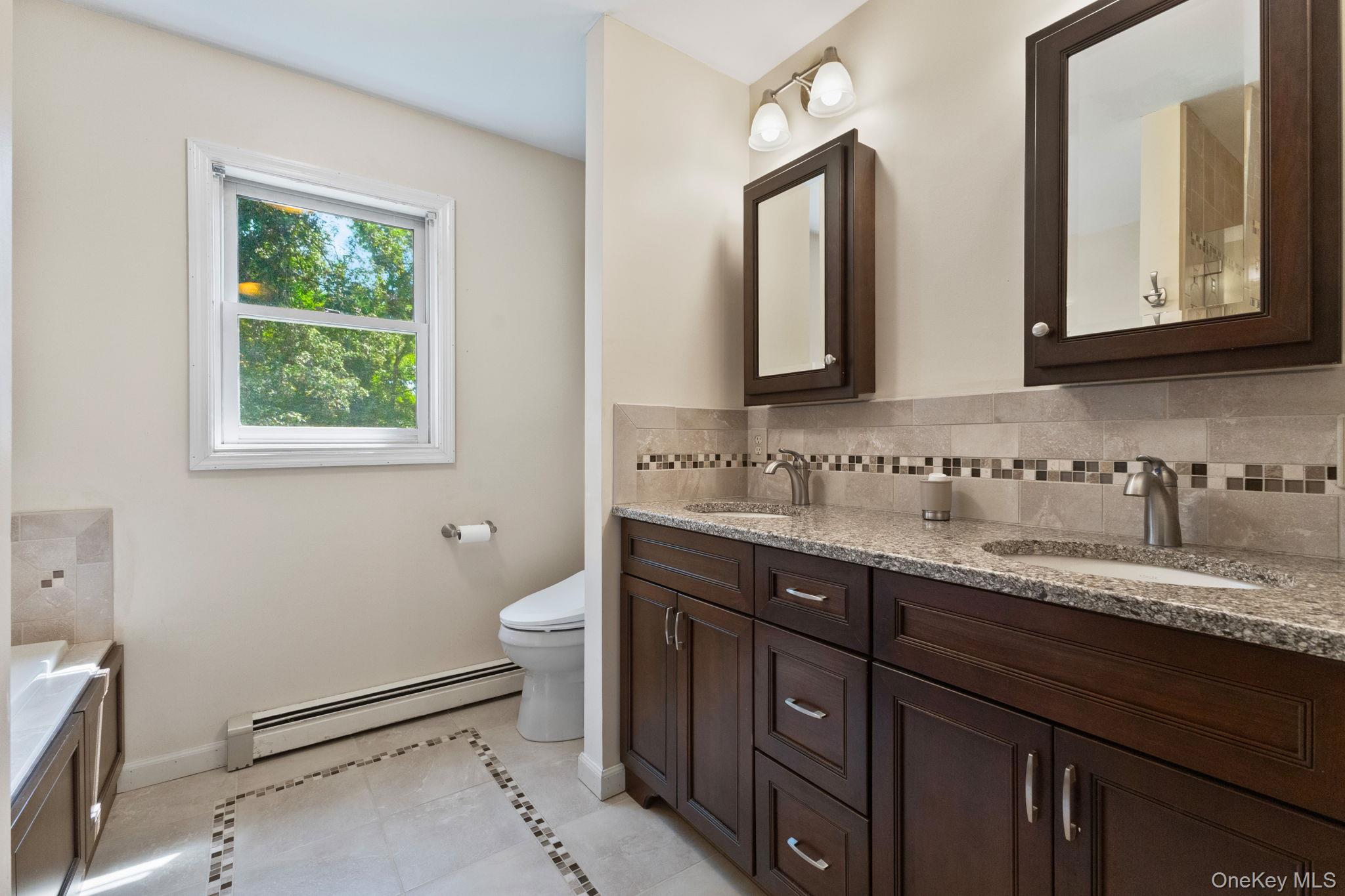 9 Windswept Circle Brewster, NY 10509 - Photo 34 of 43 a bathroom with a granite countertop toilet sink and mirror