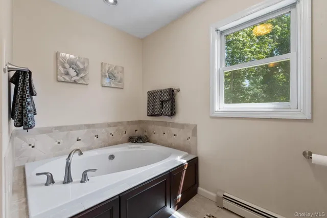 a bathroom with a bathtub and a window