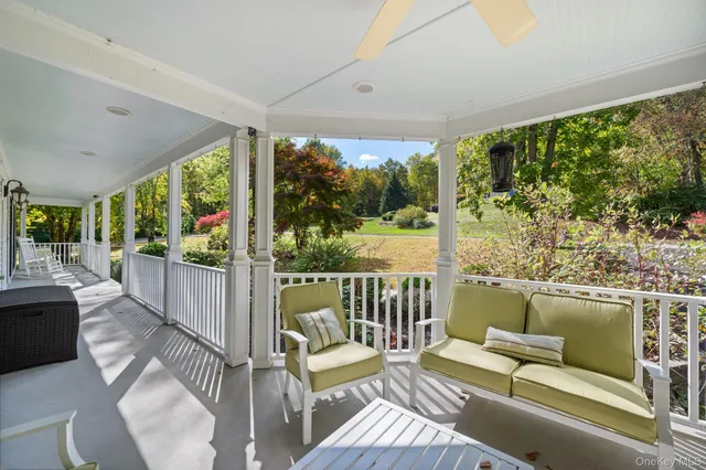 a balcony with wooden floor and outdoor seating