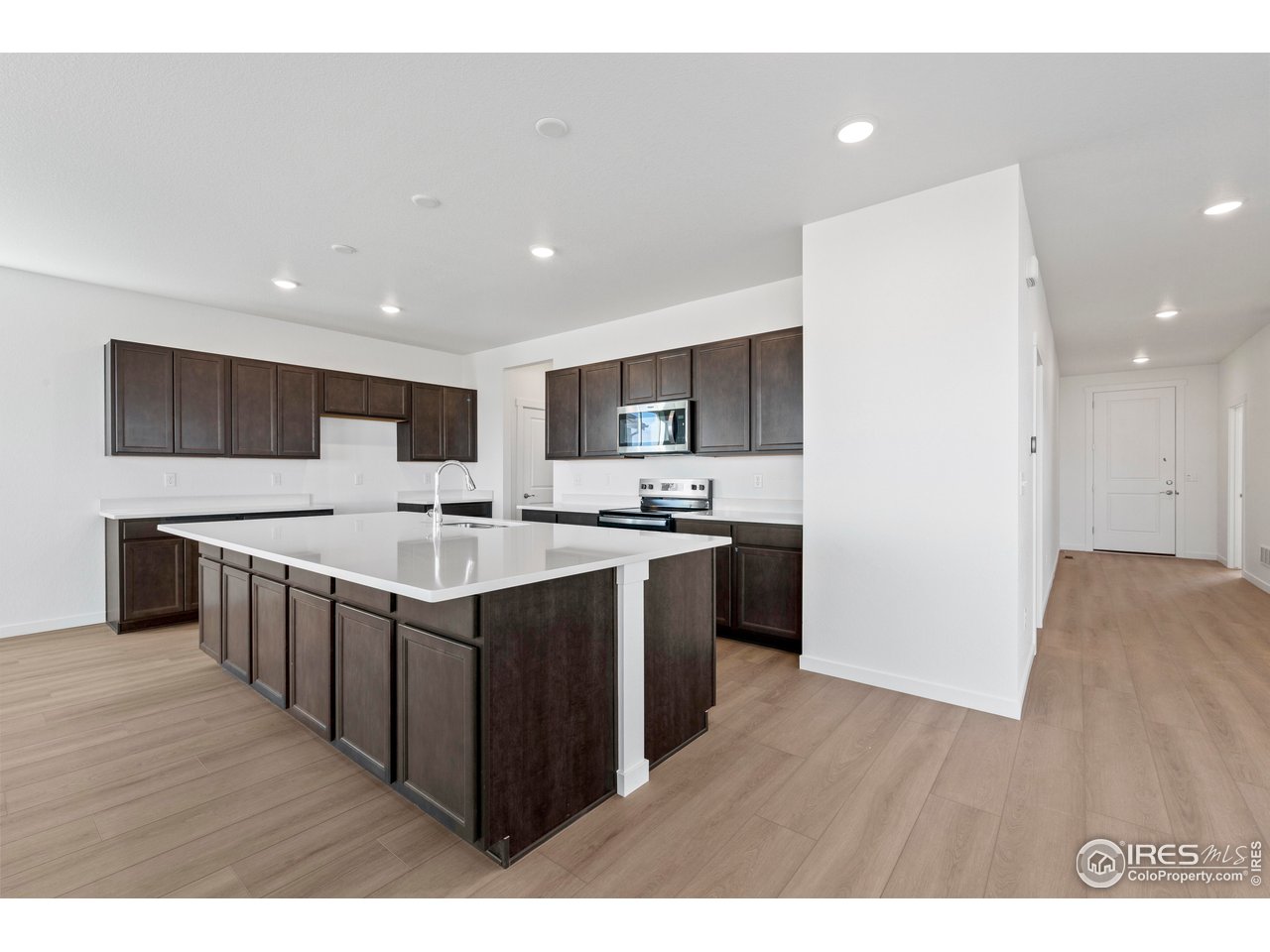 1472 Boyle Street Windsor, CO 80550 - Photo 6 of 25 a kitchen with stainless steel appliances granite countertop a sink a stove top oven a wooden floors