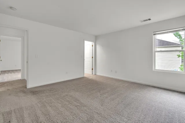 an empty room with windows and closet