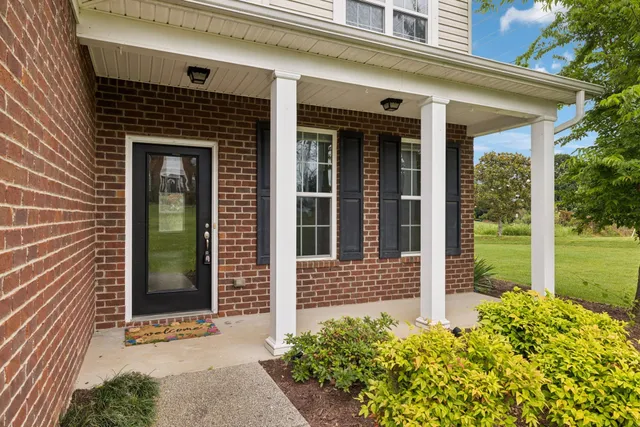a aerial view of a house next to a big yard and large trees