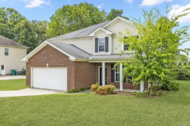 a front view of a house with a yard and garage