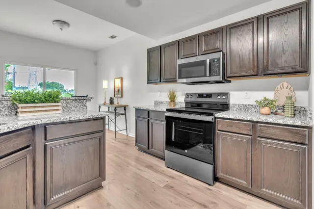 a kitchen with granite countertop stainless steel appliances and wooden cabinets