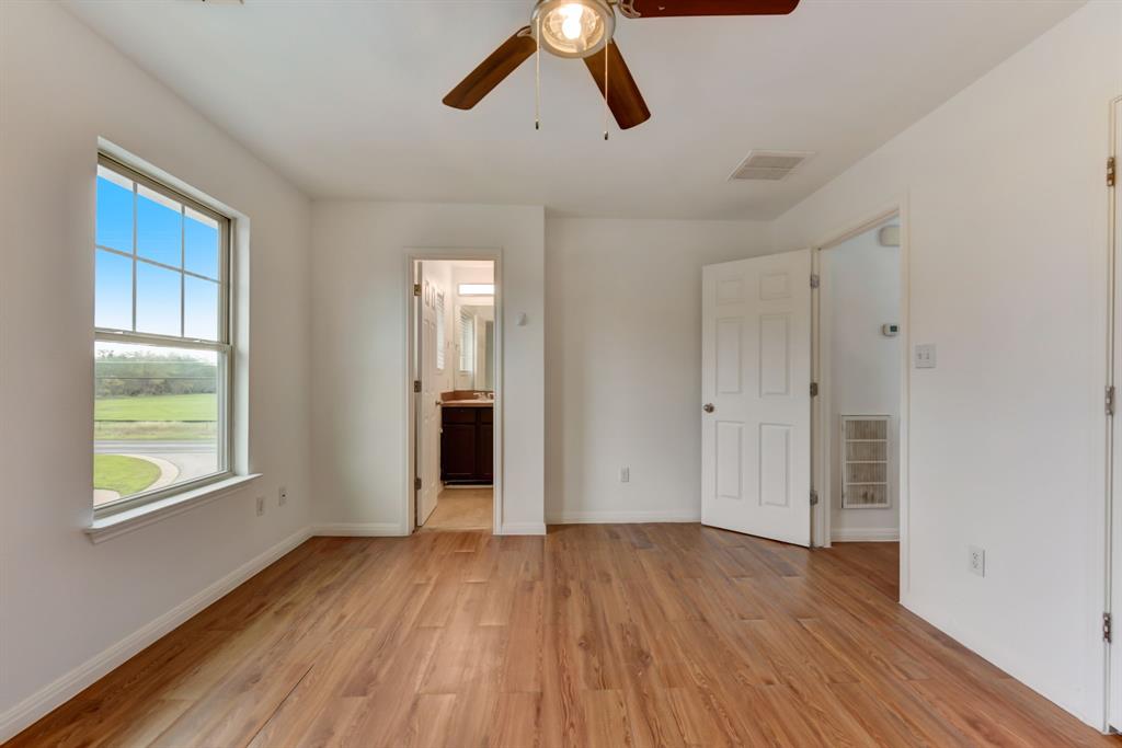 4502 Kind Way Austin, TX 78725 - Photo 11 of 13 Unfurnished bedroom with ensuite bathroom, light wood finished floors, and ceiling fan