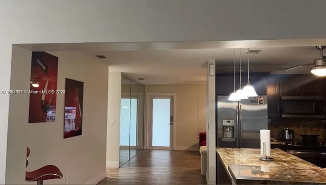 a kitchen with stainless steel appliances kitchen island granite countertop a table and chairs in it