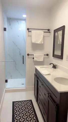 a bathroom with a sink a mirror and a shower